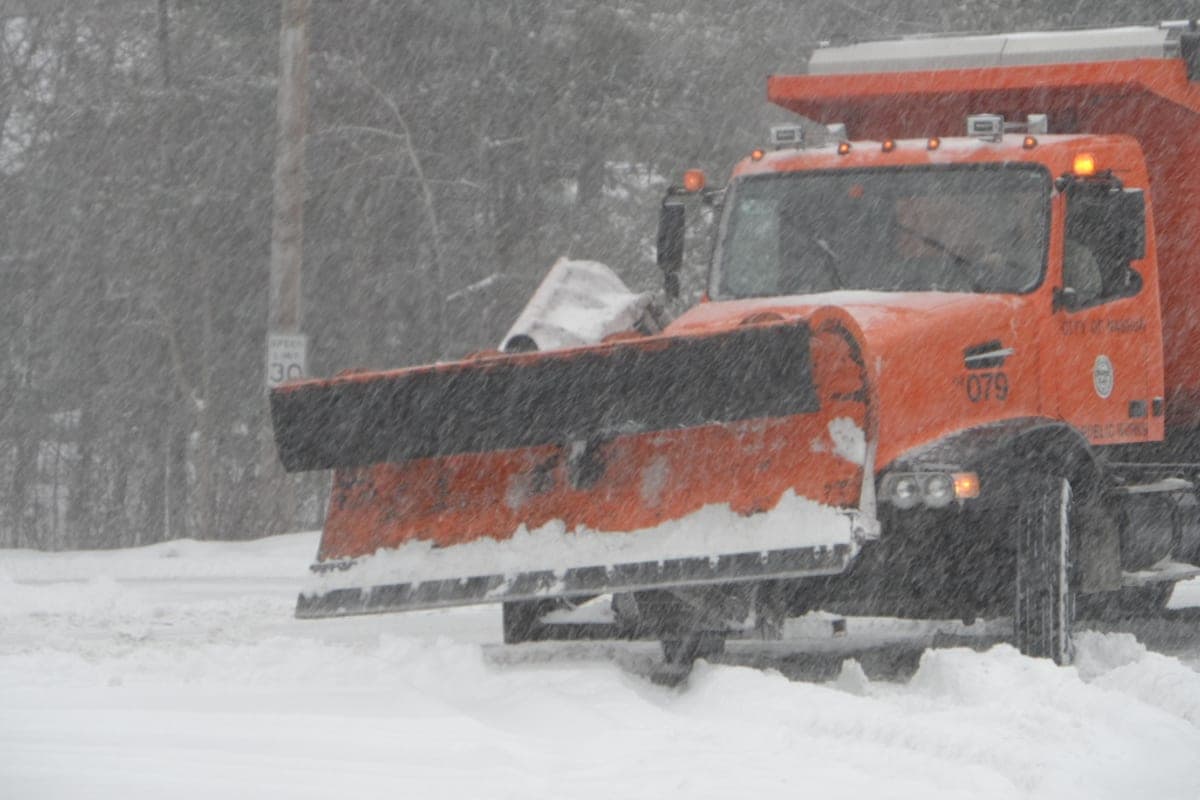 Orange city snow plow truck photographed in winter conditions