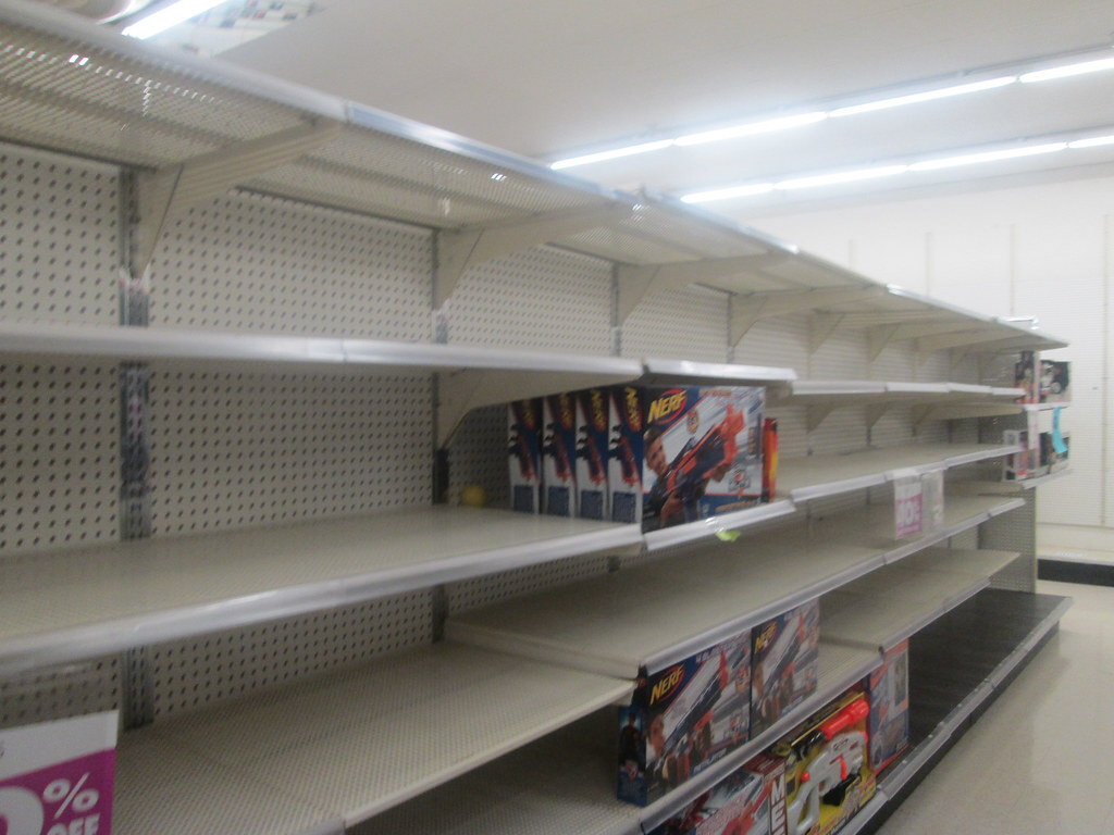 Retail shelf with large empty sections and very few products.