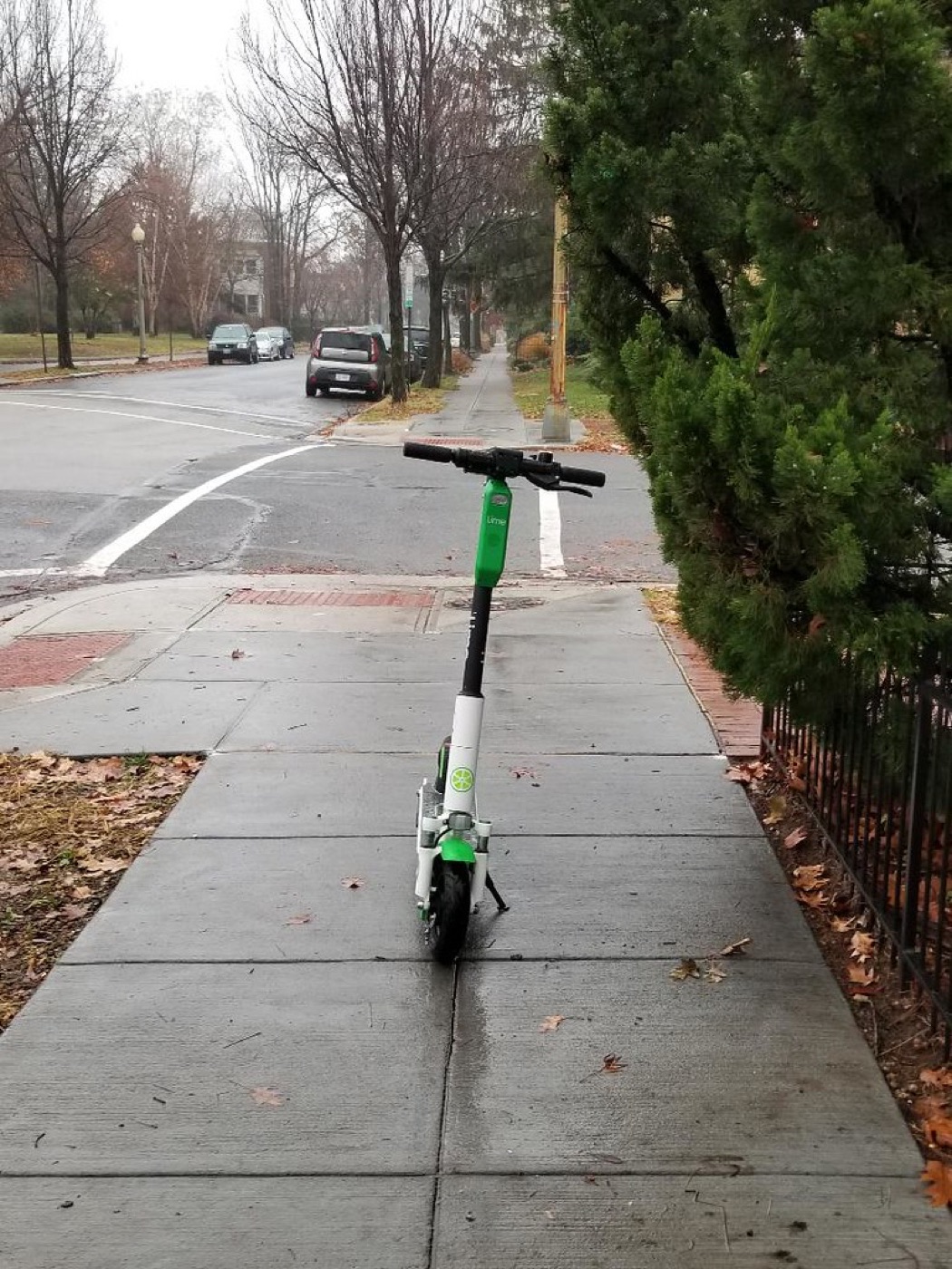 Scooter left in the middle of the sidewalk, obstructing the pedestrian path.
