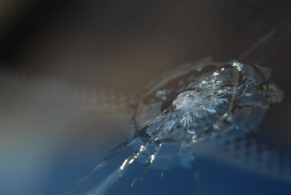 Close-up of cracked auto glass — should fail broken-glass and full-vehicle-framing checks.